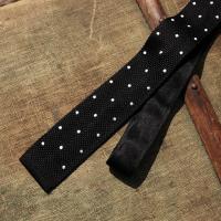 A Black silk scarf with white polkadot tie 